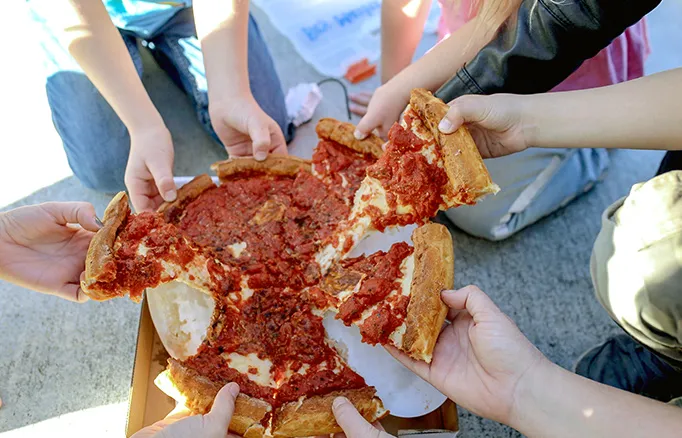 Friends sharing a Fresh Brothers pizza